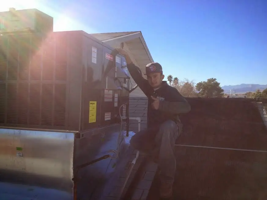 HVAC technician performing AC Tune-Up on a rooftop unit in Adairsville